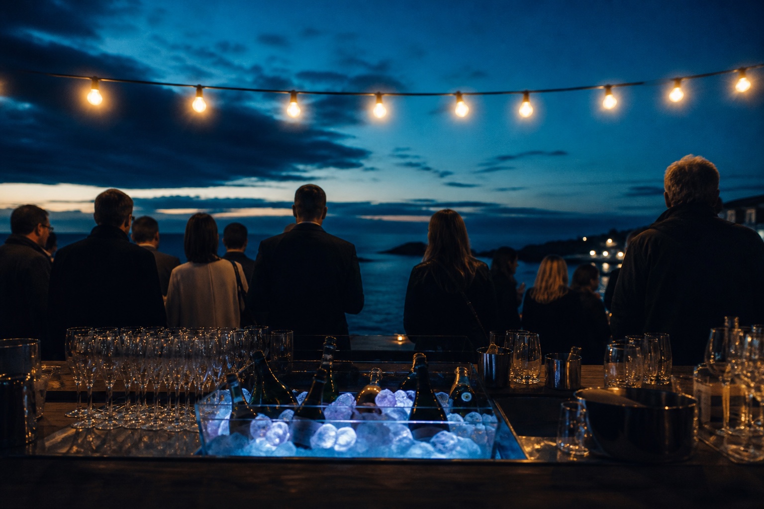Bar sous guirlandes lumineuses sur une terrasse face à la mer