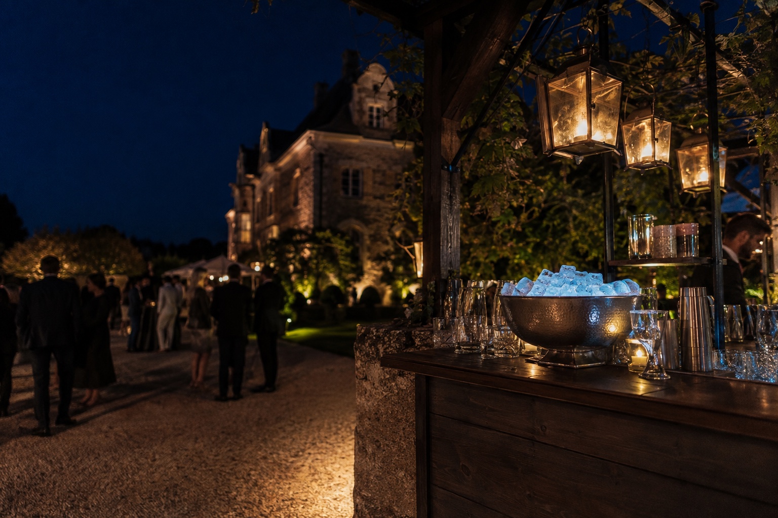 Bar extérieur sous des lanternes devant un manoir en granit